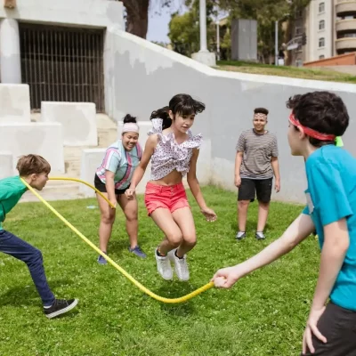 bambini che giocano all'aperto e saltano la corda