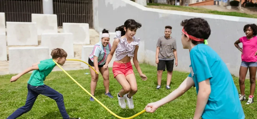 bambini che giocano all'aperto e saltano la corda