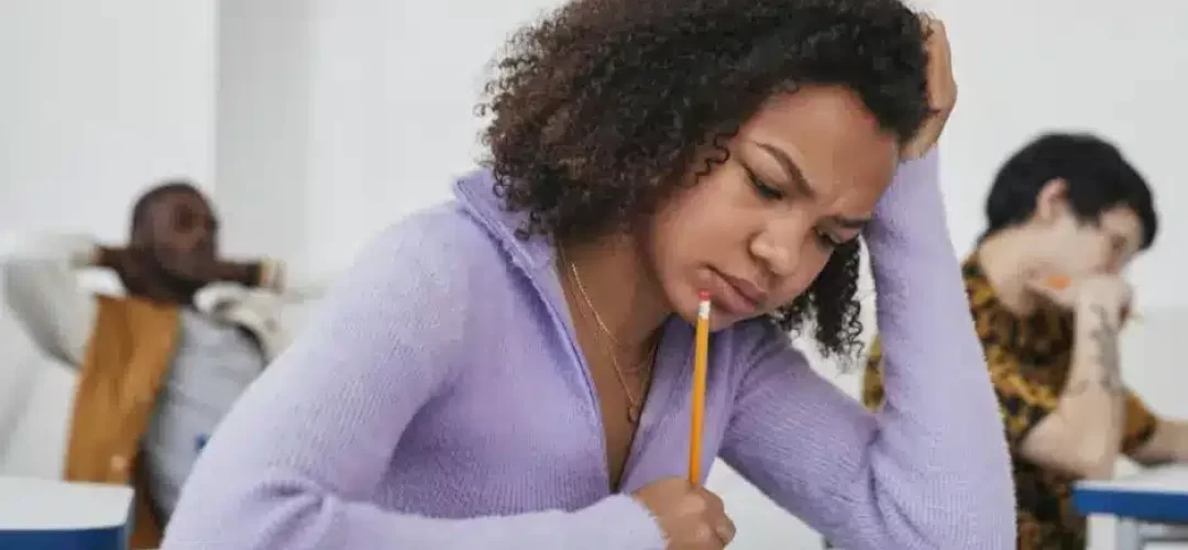 studentessa che pensa e guarda il foglio